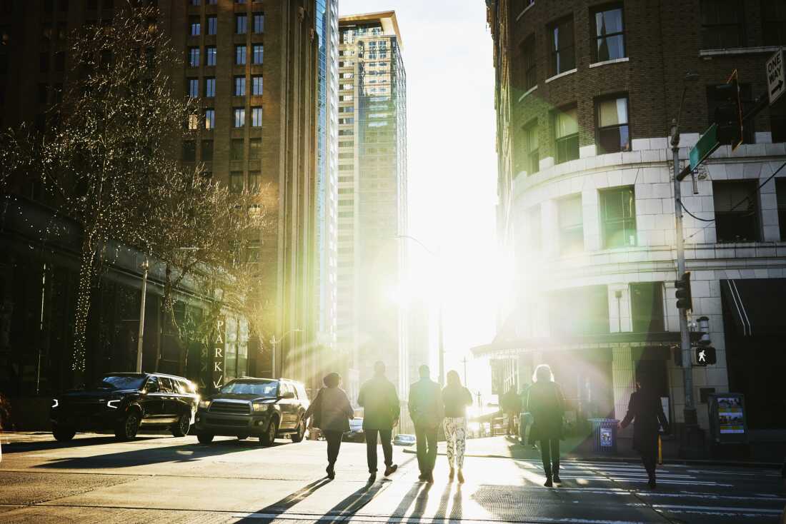 View the wide shots of business people who cross the city streets during the evening commander