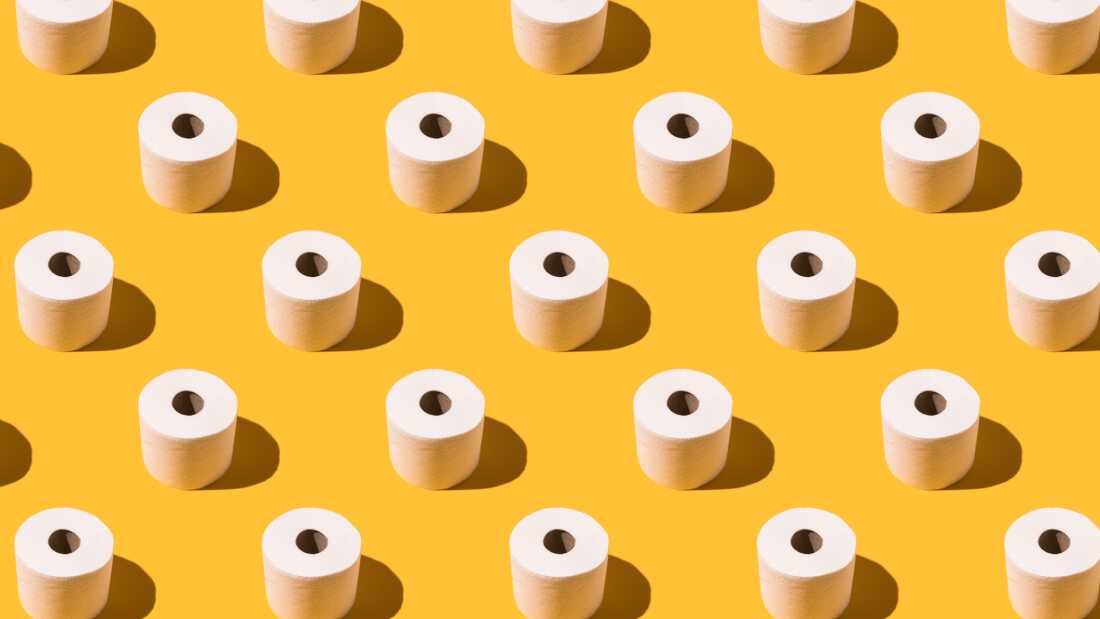 Pattern of white toilet paper rolls on yellow background. Concept of going to the bathroom, cleaning and pooping and peeing.