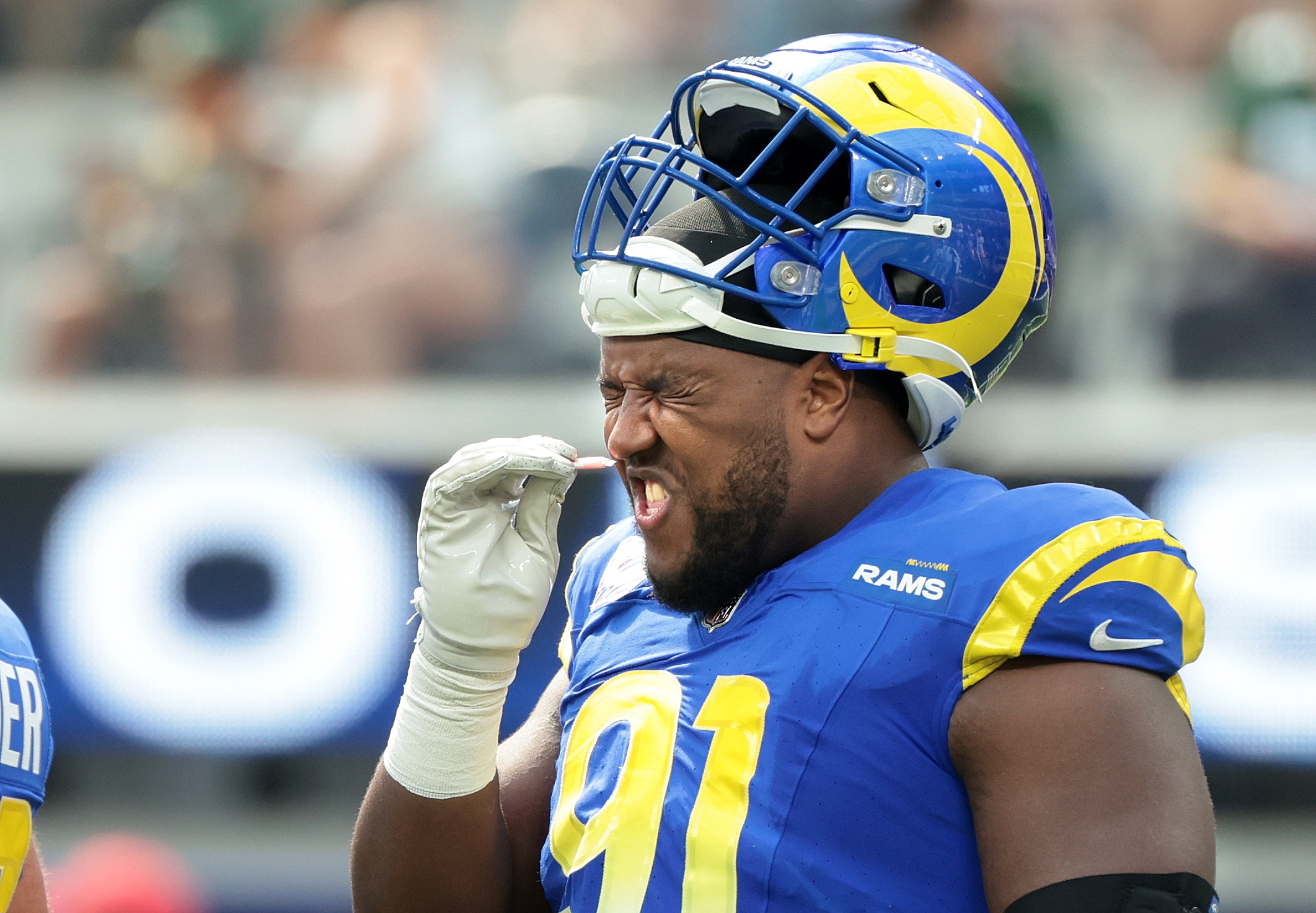 Rams defensive end Kobie Turner takes a sniff of smelling salts during a game against the Packers at SoFi Stadium in Inglewood Sunday. The NFL has banned use of the substance for safety reasons.