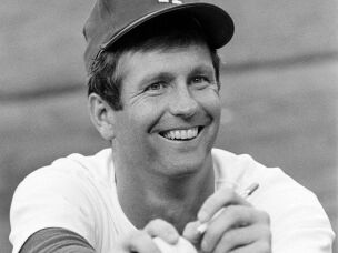Lefthander Tommy John of the Los Angeles Dodgers signs an autograph before a game on Aug. 12, 1977.