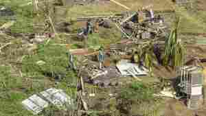 People survey their home destroyed by Hurricane Beryl in St. Vincent and the Grenadines.