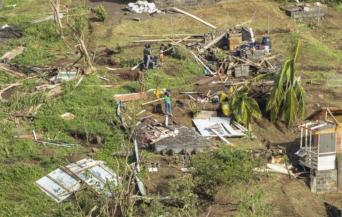 Family members survey their home destroyed by Hurricane Beryl, in Ottley Hall, St. Vincent and the Grenadines, on Tuesday. Beryl is the most powerful storm to form this early in the Atlantic hurricane season.