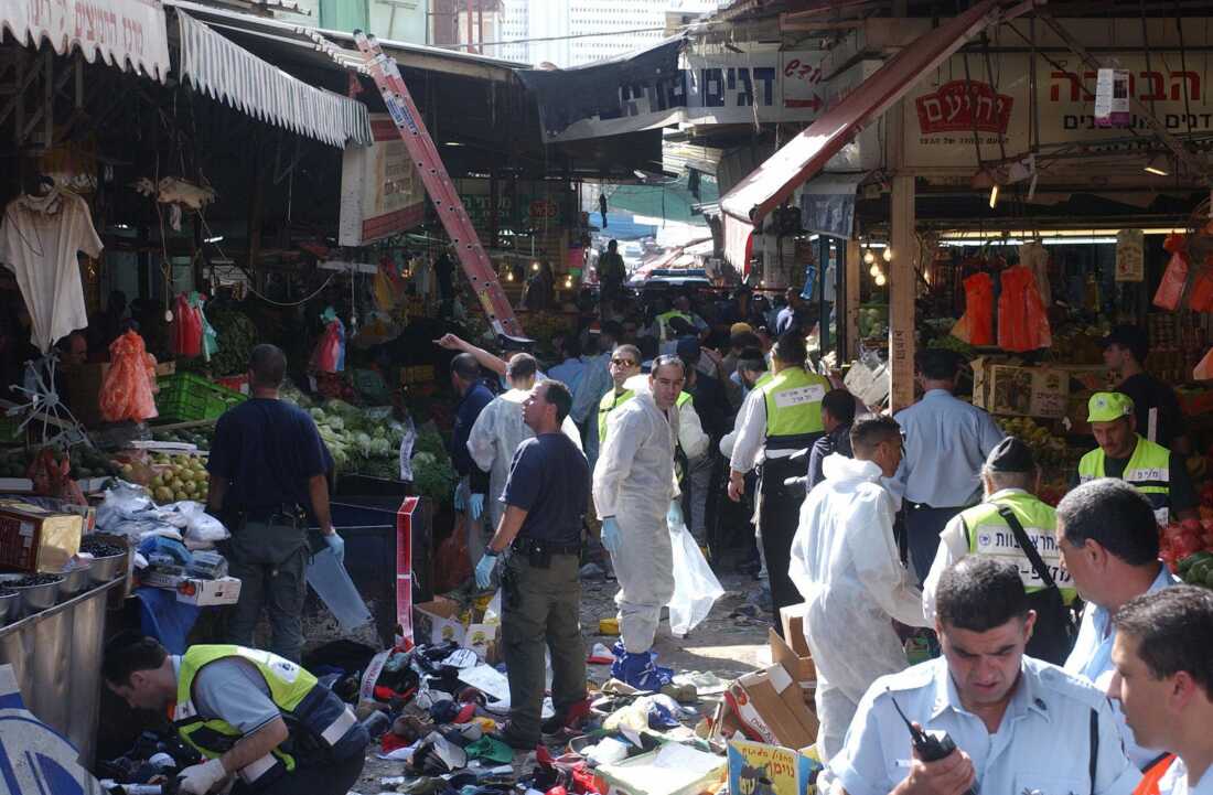 Israeli emergency crews work at the scene of a suicide bombing by a Palestinian teenager who blew himself up in a marketplace in Tel Aviv, Israel, on Nov. 1, 2004.