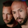 Andrew Tate and his brother Tristan Tate talk to the media outside their residence on March 23, 2025 in Bucharest, Romania.