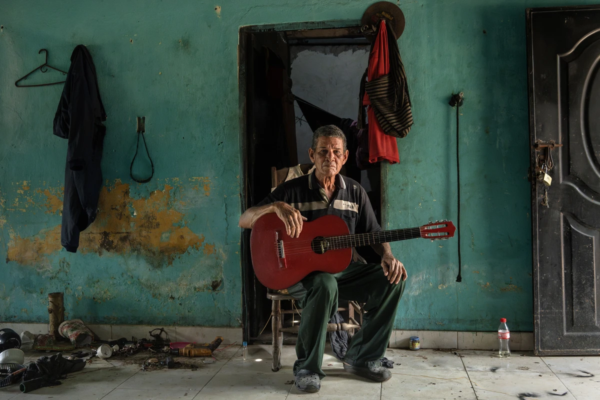 José Benito Africano Mendoza poses for a photo with his guitar in his home in El Banco Magdalena, Colombia, on Aug. 7, 2022.