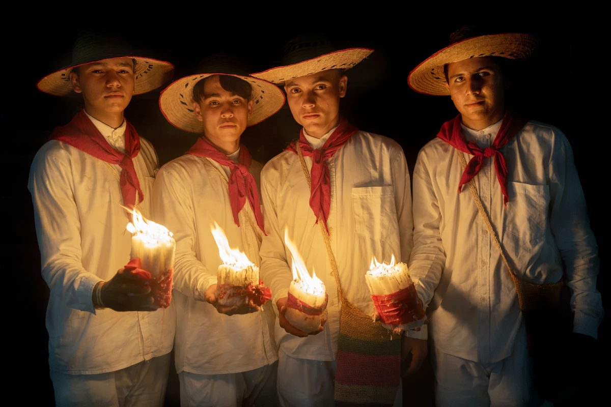 Diomar Trigos (from left to right), Esneider Páez, Humberto Cañizares and Sebastián Suárez stand in the street after participating in the Pocabuyano Parade in El Banco, Magdalena, Colombia, during the National Festival of Cumbia, on Oct. 15, 2022. They are representing the town of San Alberto, Cesar, and are wearing traditional cumbia clothing.