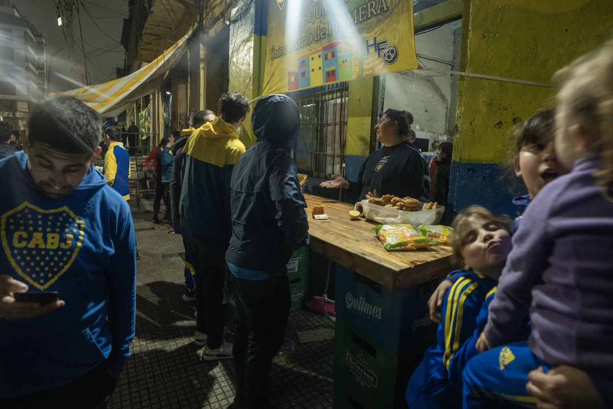People gather for a street party in Buenos Aires' La Boca barrio before a soccer match at the La Bombonerita stadium on July 31, 2024. Pre-game celebrations take place throughout the area, with cumbia bands often hired to perform outside food and drink establishments.