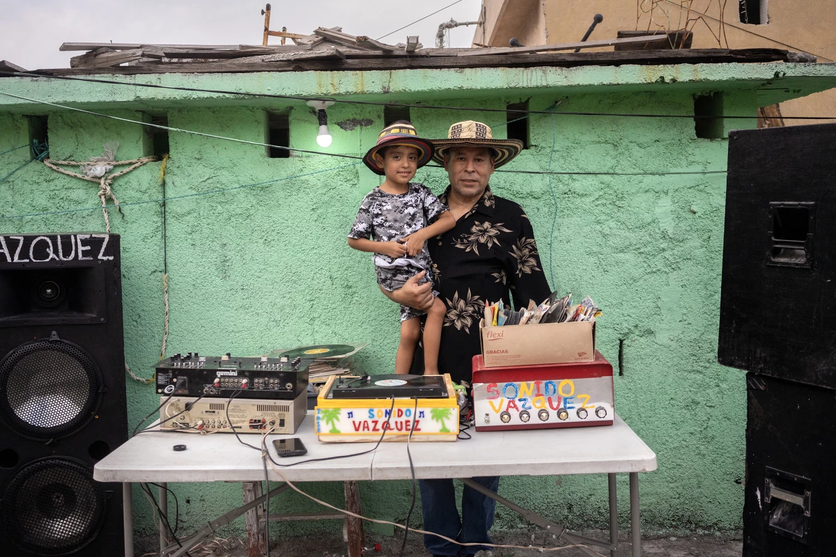 Jose Catarino Vazquez Villegas and his grandson, Jesus Alejandro, pose for a portrait at their home in the Independencia neighborhood on Aug. 9, 2023. Vazquez is a renowned sonidero, or cumbia DJ, in La Independencia.