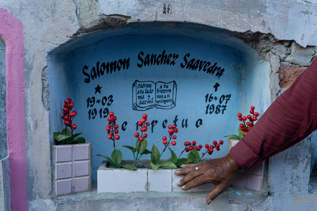 Helner Misael Sánchez Casanova, known as Tacto, a member of Los Wembler's de Iquitos, visits the grave of his father, Salomon Sánchez Saavedra, at Lima's cemetery of El Sauce on Oct. 28, 2024. Salomon founded the band with his five sons in 1968.