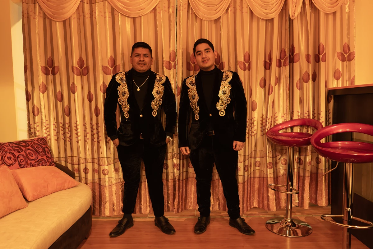 Jose Luis Mendoza Zapata, bongo player, and Leandro Lozada, singer of Armonía 10, pose for a photo in their hotel room before a concert in Sicuani, Peru, on Nov. 4, 2024.
