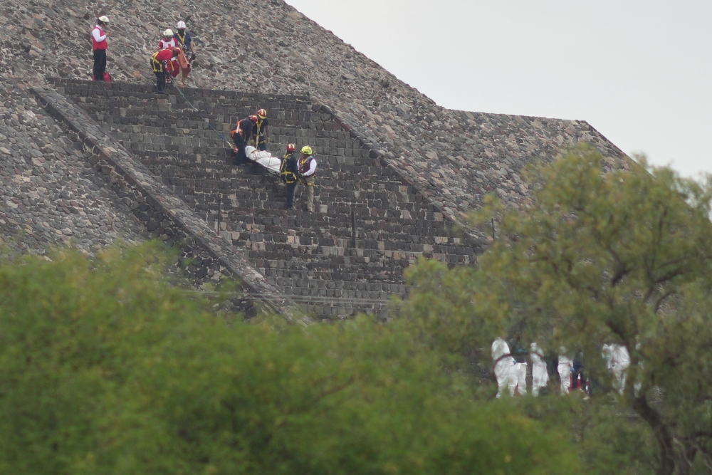 Forensic workers carry the body of a victim down a pyramid after authorities said a gunman opened fire, in Teotihuacan, Mexico, Monday, April 20, 2026. (AP)