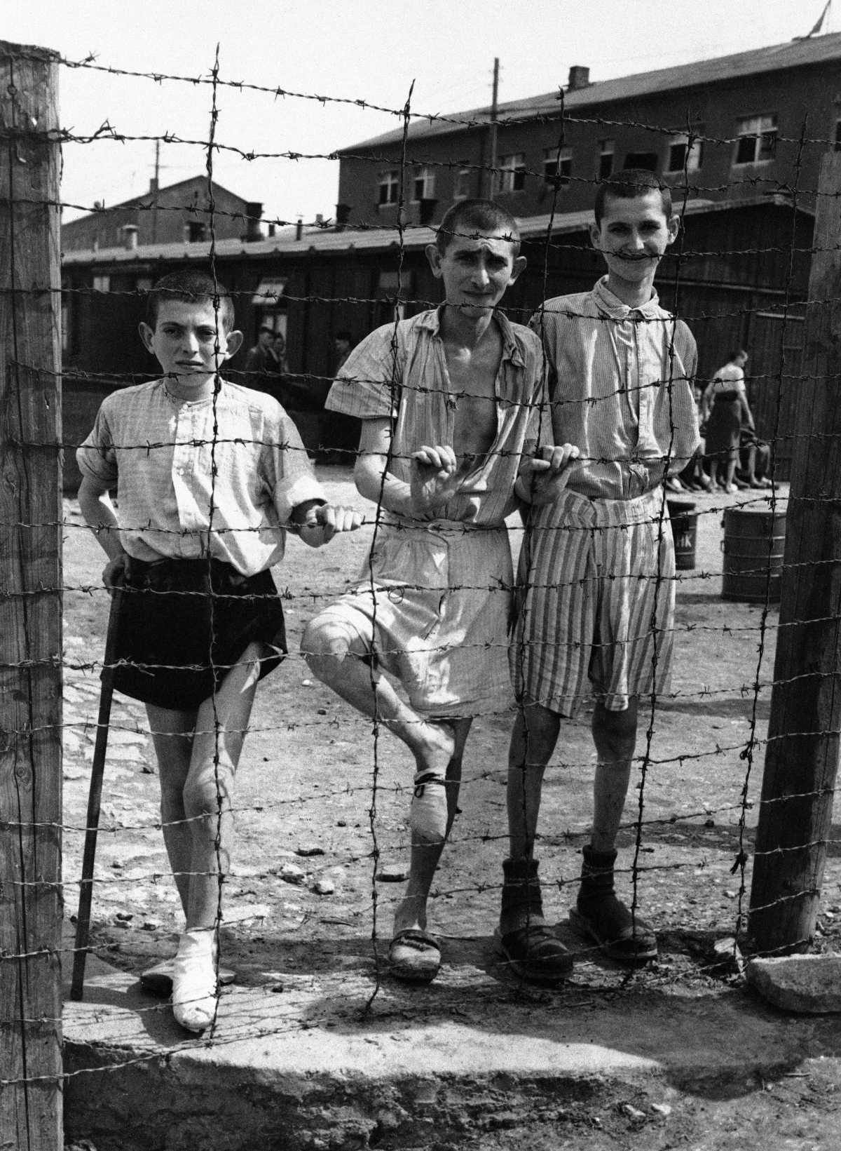 Young, emaciated prisoners stand inside the barbed wire of the Buchenwald concentration camp on April 19, 1945, shortly after the U.S. army liberated the camp from the Nazis.