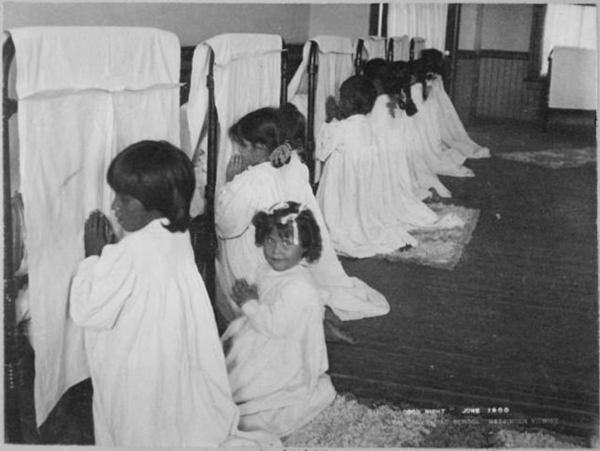 “Little Girls Praying Beside Their Beds, Phoenix Indian School, Arizona,” 1900; Exhibit Prints Related to Various Jurisdictions, Tribes, Indian Schools and Activities, 1904-1936; Records of the Bureau of Indian Affairs, Record Group 75; National Archives at College Park, College Park, MD.