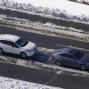 Stranded motorists in two vehicles, a four-door sedan and an SUV, wait for a tow on Interstate 95 in 2022 in Ladysmith, Virginia. Snow and ice cover portions of the highway.