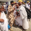 A man affected by the scorching heat is helped by another Muslim pilgrim and a police officer during the Hajj pilgrimage in Mina on June 16.