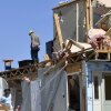 Family members cull through the debris of their home that was destroyed by a severe storm in London, Ky., on Saturday.