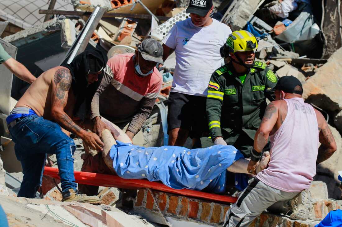 Residents and police carry a survivor pulled from the rubble after an earthquake struck Pereira, Colombia, Monday, Aug. 10, 2026.