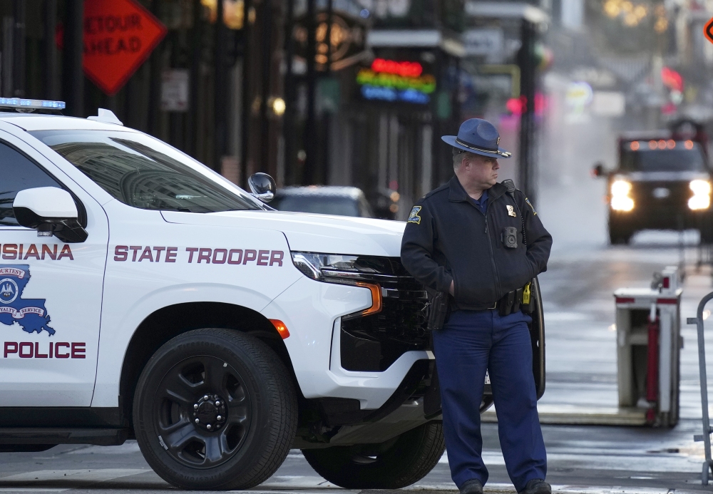 A state trooper stands by New Orleans' Canal and Bourbon streets on Thursday, the day after a truck slammed into a crowd on Bourbon Street, killing at least 14 people. (AP)