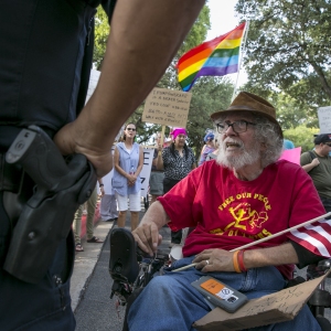 Bob Kafka, a disabled Vietnam veteran, talks with an Austin Police Officer as he and others try to enter a hotel property.