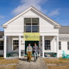 Izzy Johnson, left, and Jack Beatson are first-year students at Sterling College in Craftsbury Common, Vermont. The two students are walking out of the college building into the yard. 