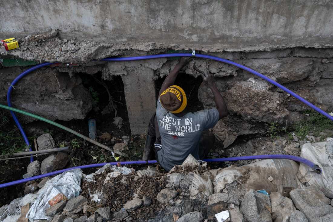 A member of a water cartel in the slum community of Kibera, hammer in hand, cuts into a municipal water pipe to siphon off water illicitly. That water is then sold to residents who aren't able to get government-supplied water.