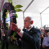 Israeli Prime Minister Benjamin Netanyahu holds up a wreath as he places it during a state memorial ceremony in memory of those killed in the October 7, 2023, Hamas-led attack on Israel, at Mount Herzl cemetery in Jerusalem on October 5. Rows of people are standing behind him.