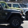 Jeep Wrangler 4Xe plug-in hybrids displayed on the sales lot at Hilltop Chrysler Jeep Dodge Ram in Richmond, California.