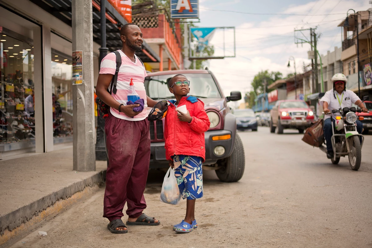 Didier Betofe, from the Congo, Africa, and his 6-year-old son clean windshields and beg for money in the Mexican town of Ciudad Acuña across from Roma, Texas.   Didier arrived in Ecuador and traveled north to Ciudad Acuña, where they have been living the past three months.