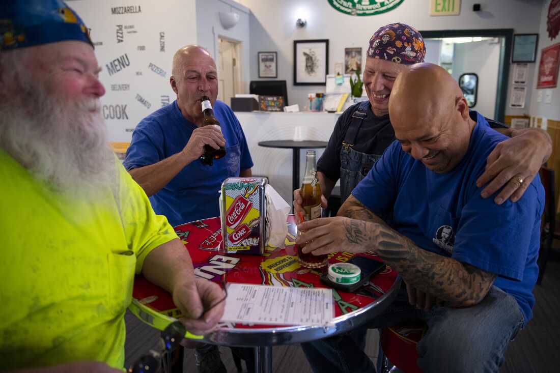 From left, electricians Mike Kane, Rick Lebel, Scott Young and Jimmy Ortega, laugh together at IBEW Brotherhood Night at Monkey N’Around Pizza on Thursday, July 17, 2025, in Quincy, Washington. 
