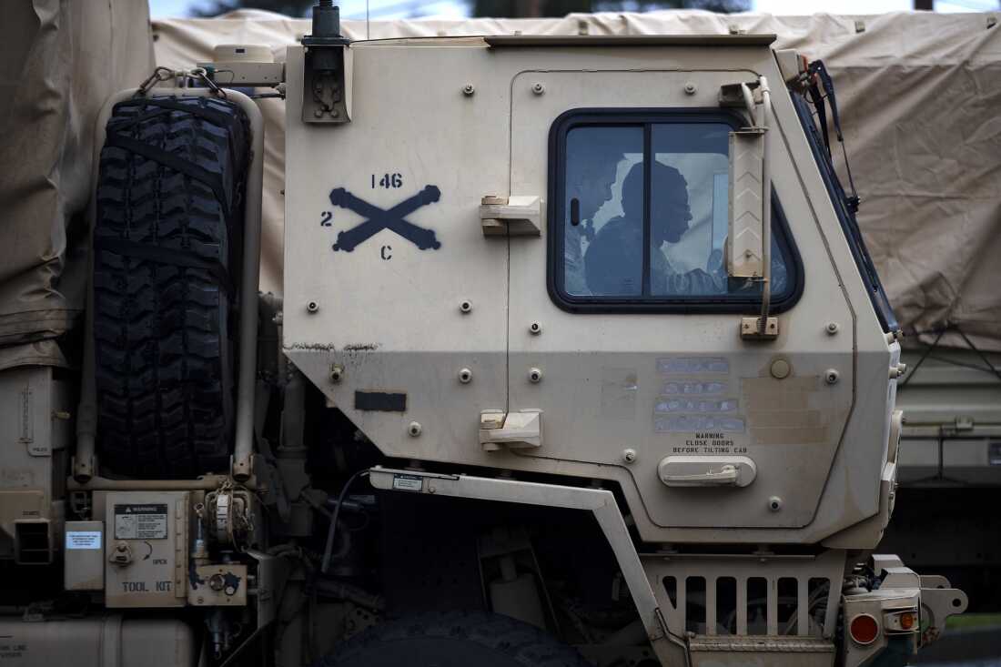 National Guard members in an armored truck gather at the Burlington Parks and Recreation Department before assisting in evacuations as floodwaters rise in Burlington on Friday.