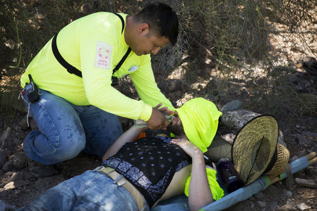 Jose Genis helps a first-time volunteer after he experiences signs of heat stroke during Aguílas del Desierto search and rescue crew's mission recover bodies of migrants in order to turn them over to the Pima County coroner and provide their families some closure on May 27, 2017 in the Cabeza Prieta wilderness near Ajo, Ariz. (Photo by Caitlin O'Hara/Getty Images)