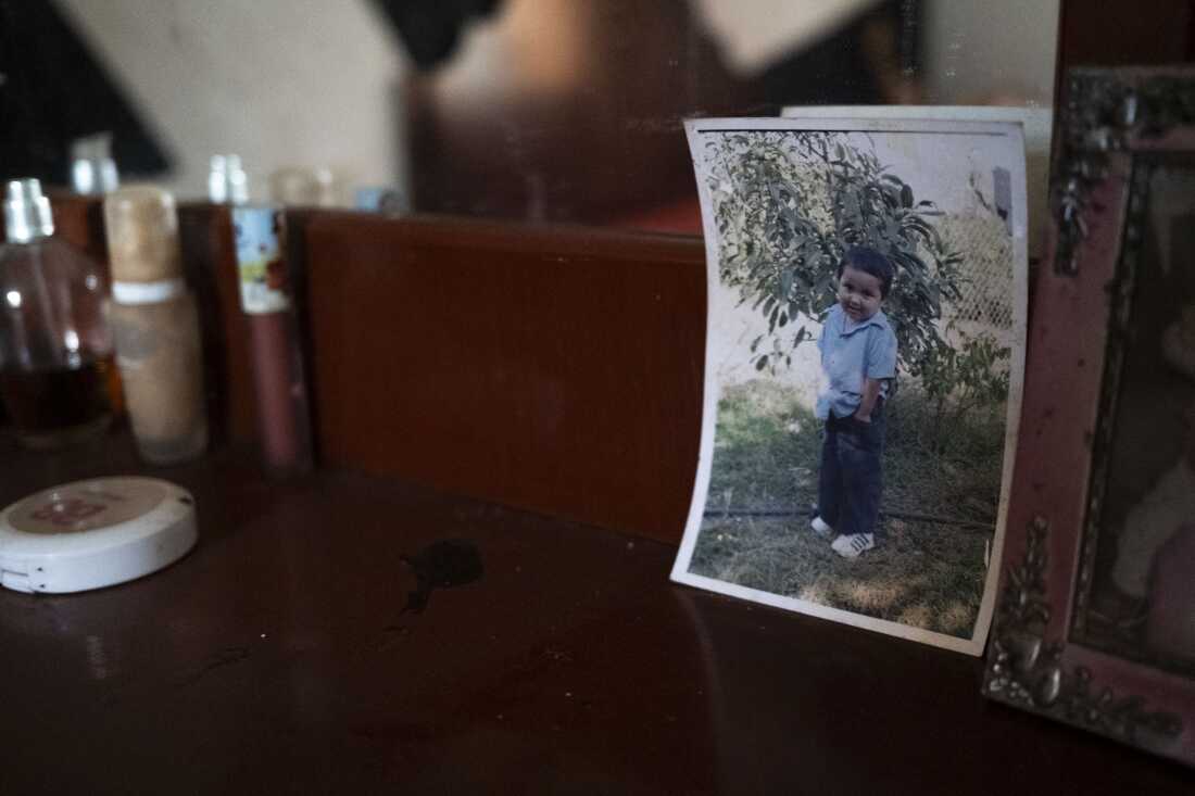 A photo of Kevin as a child stands on a table in his family’s abandoned house in Michoacán, Mexico on November 14, 2022. The house has remained abandoned and all their belongings remain in the same place.