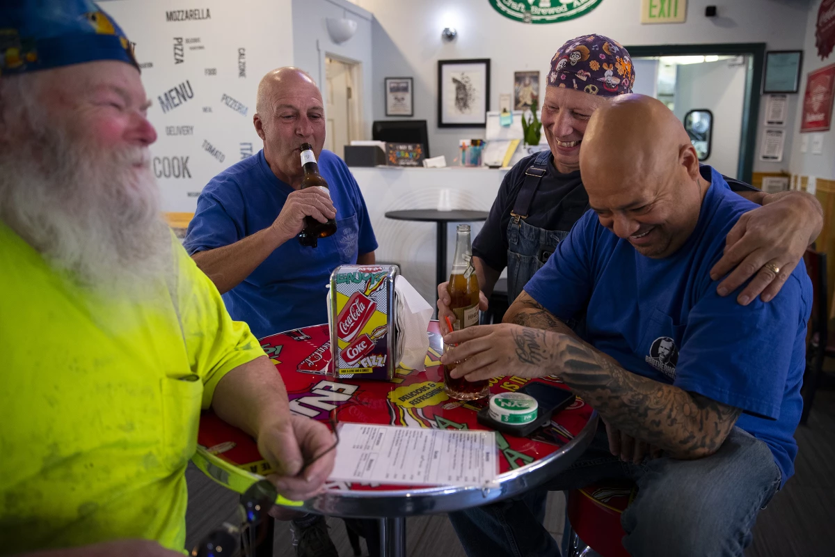 From left, electricians Mike Kane, Rick Lebel, Scott Young and Jimmy Ortega, laugh together at IBEW Brotherhood Night at Monkey N'Around Pizza on Thursday, July 17, 2025, in Quincy, Washington.