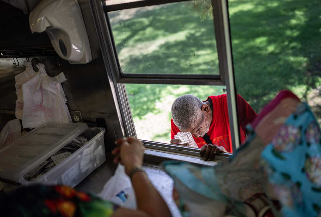 Joseph Guillory rubs his head with ice given to him at a Salvation Army truck handing out water, and other supplies in Tucson in July last summer.