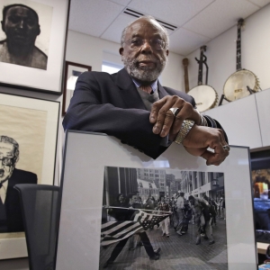 Theodore Landsmark, lawyer, architect and director of the Dukakis Center for Urban and Regional Policy at Northeastern University poses for a photo in his office in Boston, Tuesday, March 27, 2018. Pictured in Landsmark's office are a sketch of King, top left, a portrait of Supreme Court Justice Thurgood Marshall, bottom left, and a Pulitzer Prize-winning photograph by Stanley Forman, which shows Landsmark being assaulted in 1976 by a demonstrator carrying a flagpole bearing the American flag.