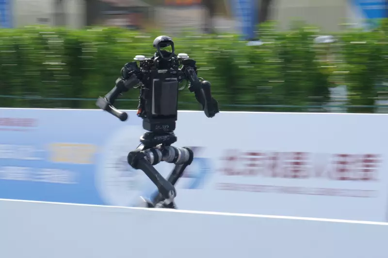 A robot runs as it competes in the Beijing E-Town Half Marathon and Humanoid Robot Half-Marathon on the outskirts of Beijing, Sunday, April 19, 2026.