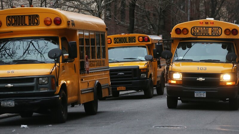 In this photo, three yellow school buses idle in a street in Manhattan's East Village on January 15, 2013.