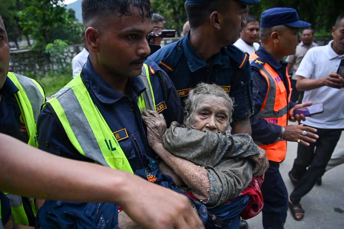 Rescue personnel carry a person affected by flash floods at Devghat in Nepal's Nuwakot district on Wednesday.