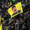 A woman waves a flag bearing a picture of the founder of the Kurdistan Workers' Party (PKK) Abdullah Ocalan, as people gather in the Kurdish-majority city of Qamishli in northeastern Syria to listen to a message from the jailed leader on Feb. 27.