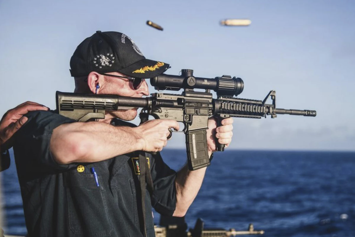 This undated photo, provided by Stars and Stripes, shows Cameron Yaste, commanding officer of the destroyer USS John McCain, firing a rifle with a backwards scope.