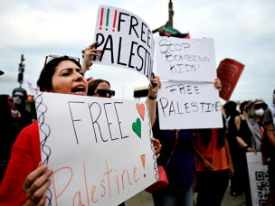 Pro-Palestinian demonstrators hold signs during a 