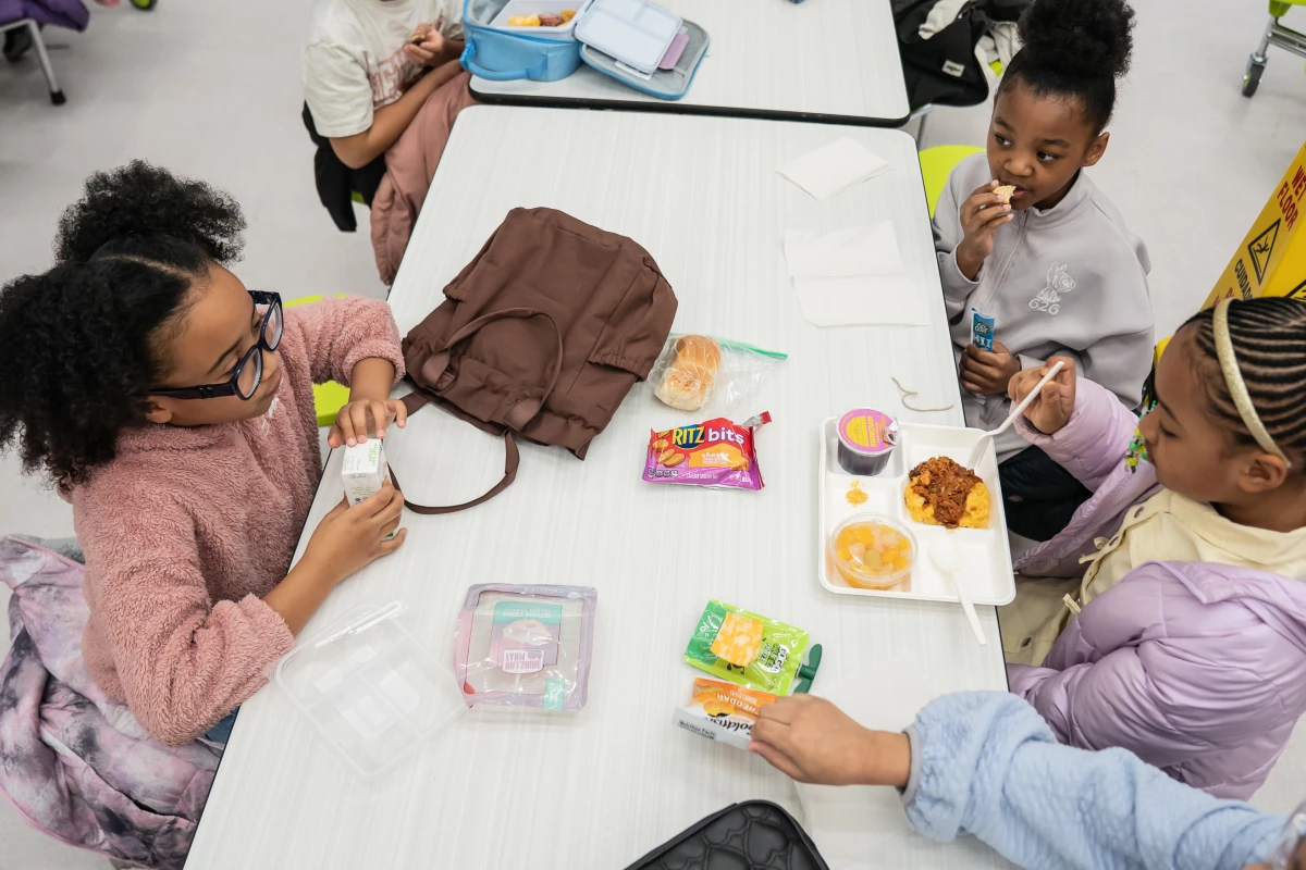 Aura eats lunch with classmates Sloane Whyte (left) and Mia Kemp.