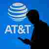 A person walked by an AT&T logo on a blue screen.