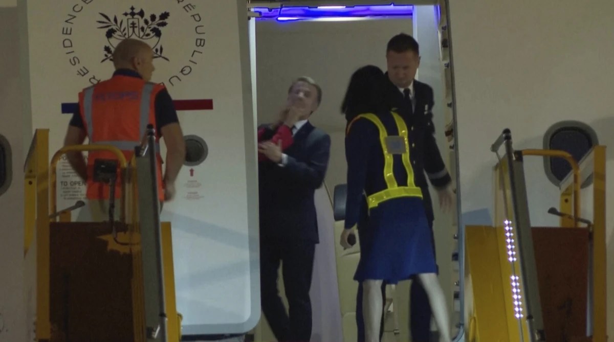 In a grab taken from video, France's President Emmanuel Macron is shoved while preparing to disembark a plane in Hanoi, Vietnam on Sunday.