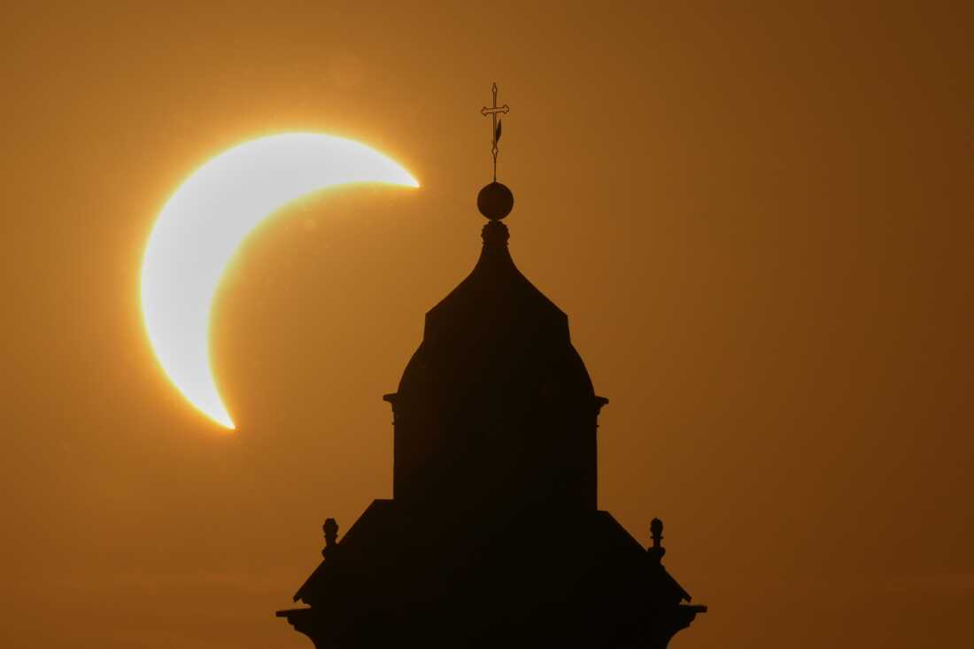 A solar eclipse is seen over a Virgin Maria church in Vidigulfo, near Pavia, northern Italy, Wednesday, Aug. 12, 2026.