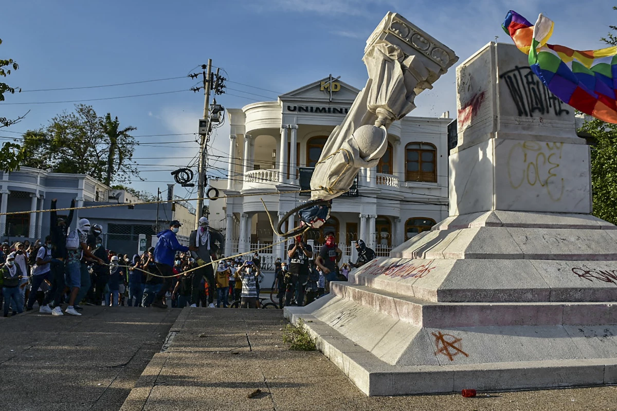 Protesters topple a statue of Christopher Columbus during a demonstration against government in Barranquilla, Colombia on June 28, 2021.