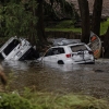 Search and rescue workers look through submerged vehicles.