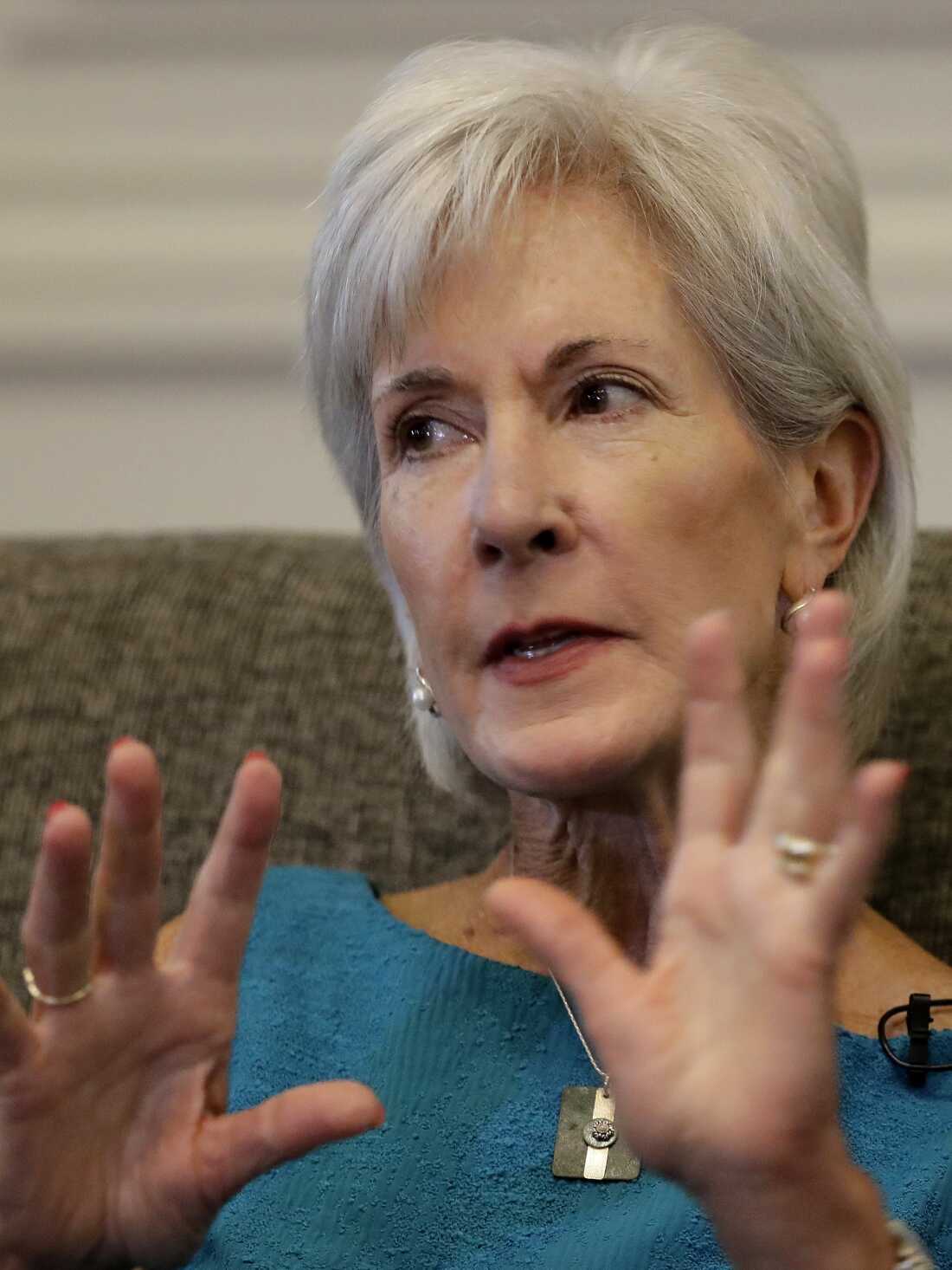 Kathleen Sebelius is shown in a portrait; she is gesticulating with her hands.