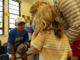 Fifth grader Gerald Gomez-Reina welcomes a new kindergartener into a classroom at Micheltorena Street Elementary School in Los Angeles, keeping his own stuffed animal, Rocket the Raccoon, handy to comfort any nerves.