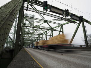 In this file photo, a logging truck drives on the Interstate 5 bridge that spans the Columbia River and connects Portland, Ore., with southwest Washington state, part of the 3rd Congressional District, on Feb. 13, 2024.